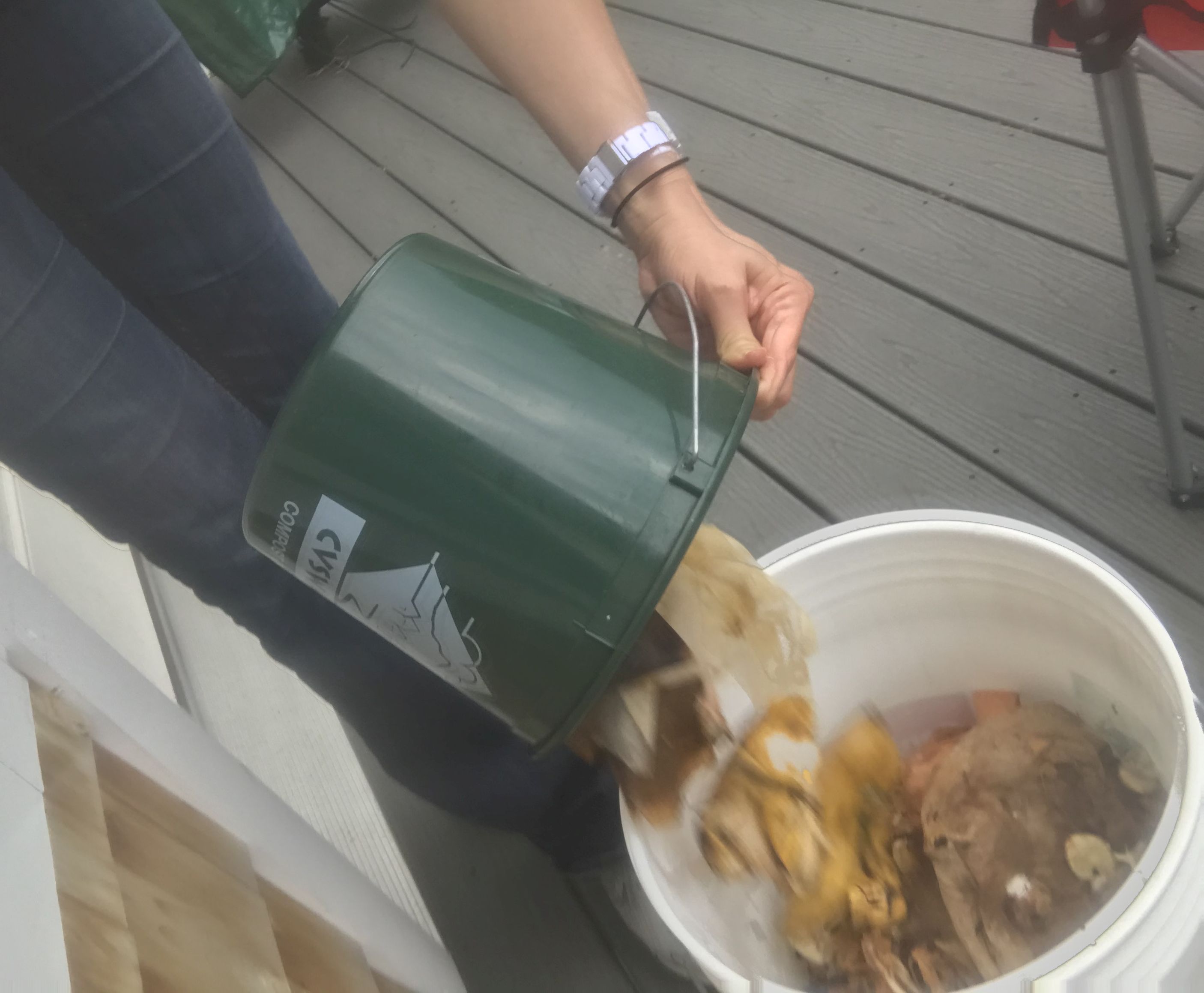 Dumping food scraps into a larger bucket